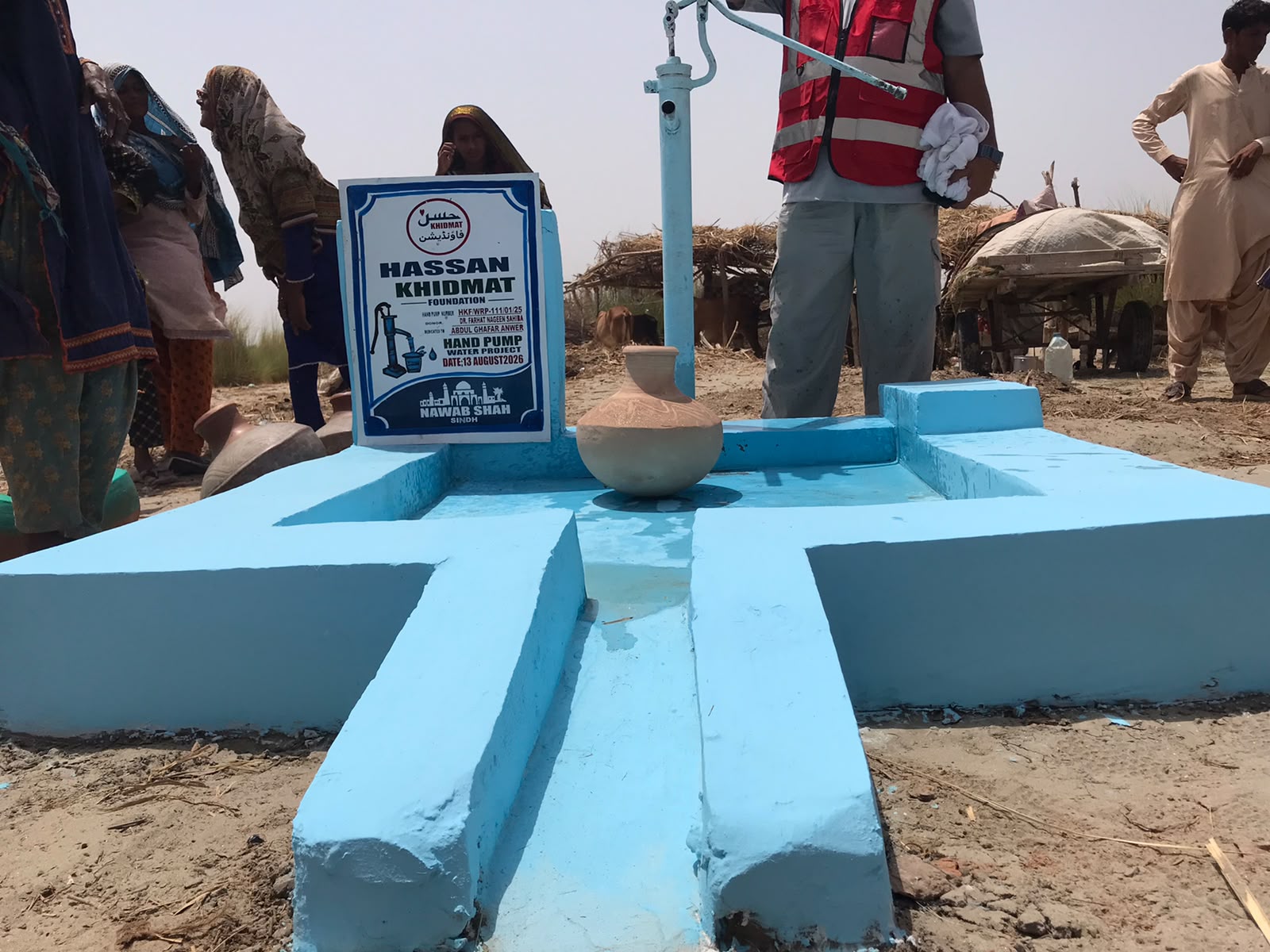 Completed blue hand pump installation in a rural village